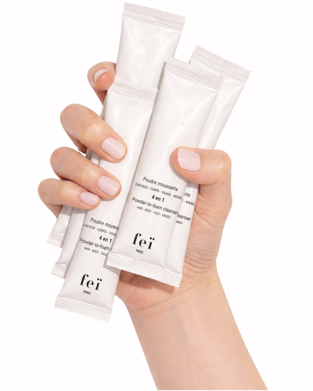 FEï cleansing powder sachets held in a hand